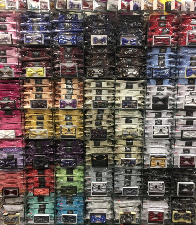 Stacks of packaged Shirts and  bow ties in various colors and designs.
